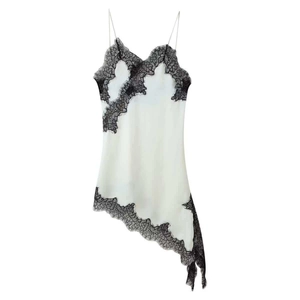 Detailed view of the fine black lace trim on the asymmetric hem of white satin dress