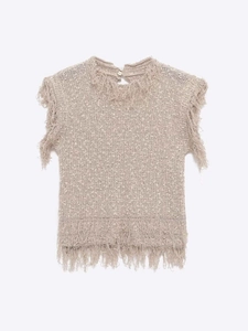 Détail du haut en maille beige avec texture épaisse et finitions à franges effilées