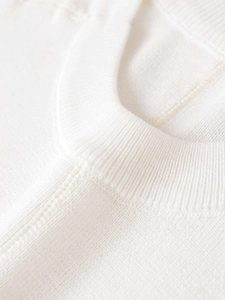 Gros plan détaillé du col côtelé et de la texture du pull en tricot blanc de qualité