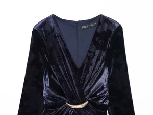 Détail de la robe midi en velours bleu marine avec col en V et boucle dorée