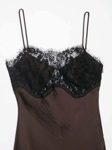 Détail d'une robe en soie marron foncé avec dentelle noire délicate et fermeture éclair invisible