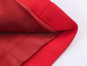 Macro detail of red double-breasted suit fabric with textured weave and silk lining