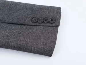 Detailed close-up of dark grey blazer sleeve cuffs with four black decorative buttons