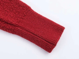 Detailed close-up of thick red knit fabric texture with ribbed cuffs and soft fuzzy finish
