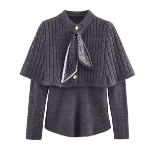 Dettaglio del set in maglia grigio scuro con motivo a trecce e sciarpa decorativa