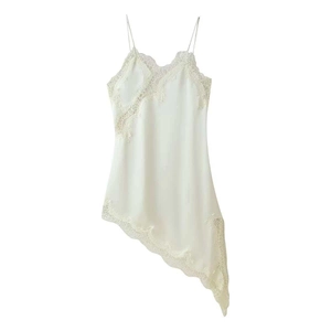 Macro detail of cream satin slip dress with intricate lace embroidery and asymmetric hem