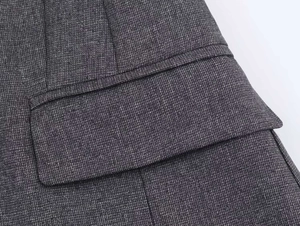 Detail of gray textured blazer showing flap pocket design and premium stitching quality