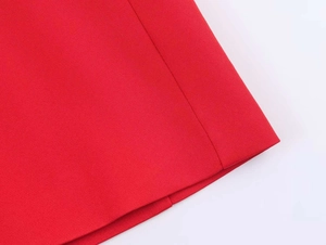 Detailed macro view of vibrant red woven fabric texture and fine stitching on the suit skirt