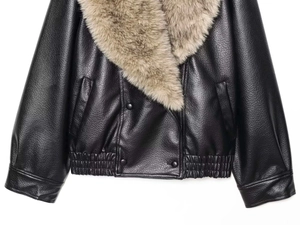 Détail d'une veste en similicuir noir avec un col amovible en fausse fourrure brune