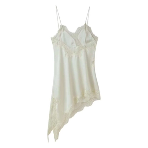 Detailed view of cream silk slip dress featuring delicate lace trim and asymmetrical hem