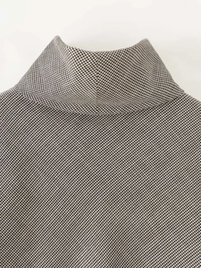 Detail close-up of high neck sleeveless houndstooth top with intricate lace stitching