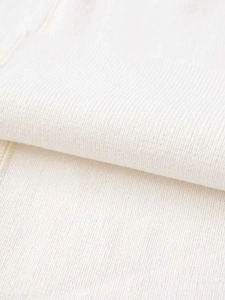 Gros plan sur un tissu en maille blanche montrant la texture côtelée et douce