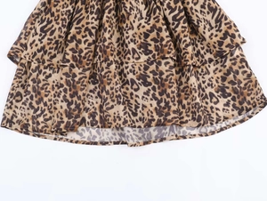 Detailed macro view of the layered leopard print fabric on a summer tiered mini dress