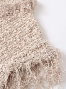 Gros plan détaillé du tissu en maille crochetée kaki clair avec bordure à franges
