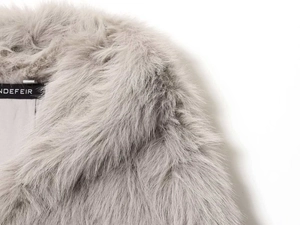 Close-up of light gray faux fox fur texture and density on a stylish winter hooded coat