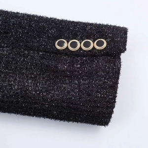 Detail of tweed blazer cuff with four gold-rimmed buttons and shimmering silver threads