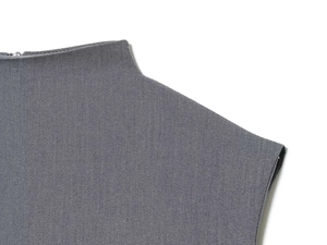 Detailed close-up of grey twill fabric featuring a metal zipper and shoulder stitching