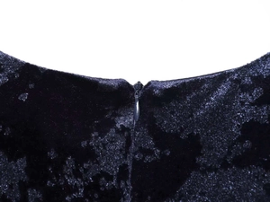 Détail du col en V d'une robe en velours avec une fermeture éclair invisible élégante