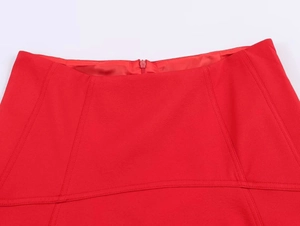 Detail view of red high-waisted skirt featuring a flat waistband and hidden back zipper
