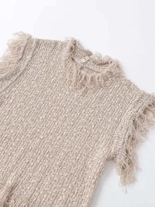 Détail d'un haut en maille kaki avec tissu bouclé texturé et bordures à franges longues