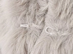 Macro detail of high-quality light grey faux fur coat with hidden metal hook closure