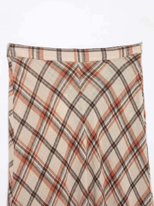 Detailed view of the orange plaid midi skirt featuring linen-like fabric and side zipper