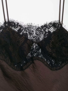 Détail d'un top en satin marron avec dentelle de cils noire délicate et fines bretelles
