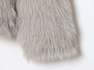 Close-up detail of soft light gray faux fur texture on a winter hooded jacket