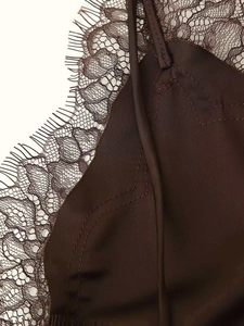 Detailed view of delicate eyelash lace trim on a dark brown satin strap dress