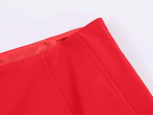 Detail of red high-waisted skirt featuring precise double-row stitching and premium fabric