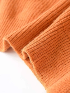 Close-up of orange ribbed knit fabric with soft texture and vertical stripe pattern