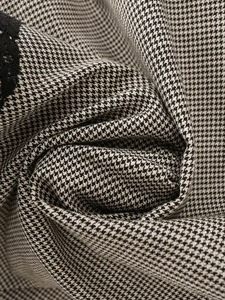 Detailed view of houndstooth fabric texture with elegant black lace stitching details