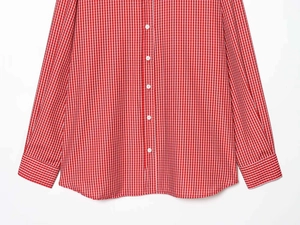 Close-up of red and white gingham pattern fabric with white button detail on shirt