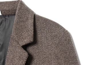 Gros plan sur le tissu à chevrons marron montrant la texture dense et la doublure