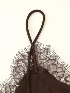 Detailed close-up of delicate eyelash lace trim and thin straps on dark brown camisole