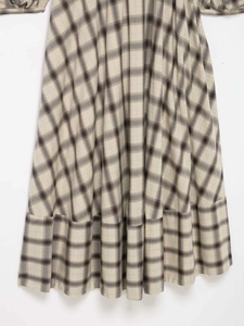 Detail of plaid dress showing tiered ruffle hem and monochrome checkered fabric texture