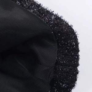 Close-up of black metallic thread jacket with plush texture and striped inner lining