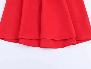 Detailed view of red double-layered skirt hem with neat stitching and high-quality fabric