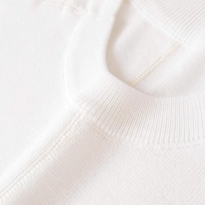 Haut en tricot blanc minimaliste avec col rond côtelé et détails de texture soignés