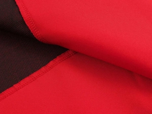 Detailed macro view of red fabric texture showing smooth weave and reinforced overlock stitching