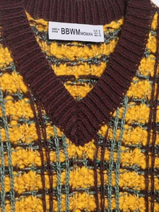 Nahaufnahme von Strickweste mit V-Ausschnitt, Farbstruktur und Pflegeetikett-Detail
