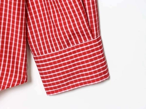 Close-up of red and white gingham shirt cuff with meticulous stitching detail