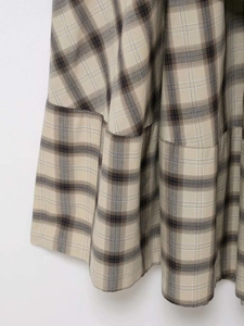 Detailed macro view of the plaid fabric pattern and stitching on a beige cotton dress