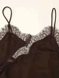 Close-up of brown satin slip dress with delicate eyelash lace trim and thin straps
