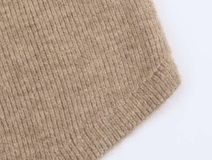 Dettaglio della trama in maglia a coste color cammello con fibre di lana morbida e rifiniture