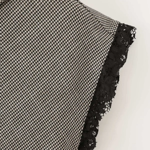 Houndstooth sleeveless top featuring a high neck and delicate black lace trim detailing