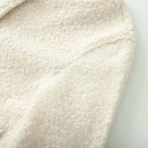 Close-up of off-white sherpa fleece texture and high-quality stitching on jacket