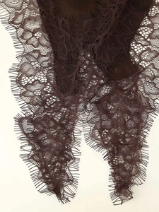 Detailed view of dark brown eyelash lace fabric with intricate floral crochet patterns