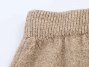 Dettaglio della trama in maglia color cammello e del girovita a costine curato