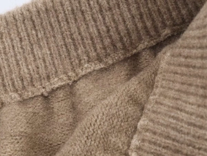 Dettaglio ravvicinato della maglia a coste color cammello con morbida trama spazzolata